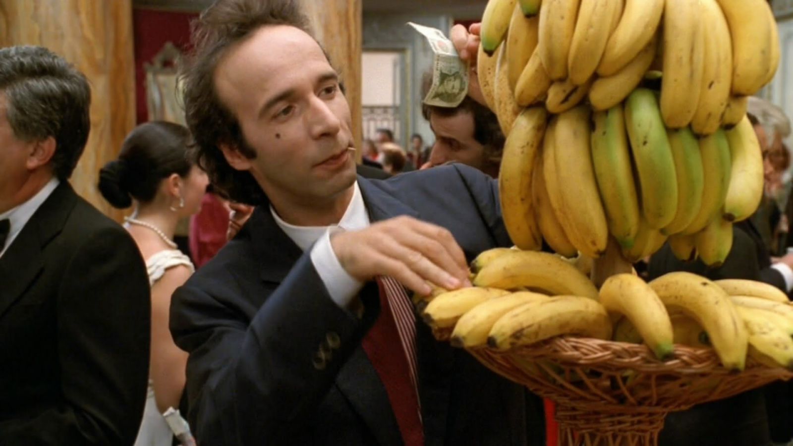 Roberto Benigni  em frente a uma pilha de bananas