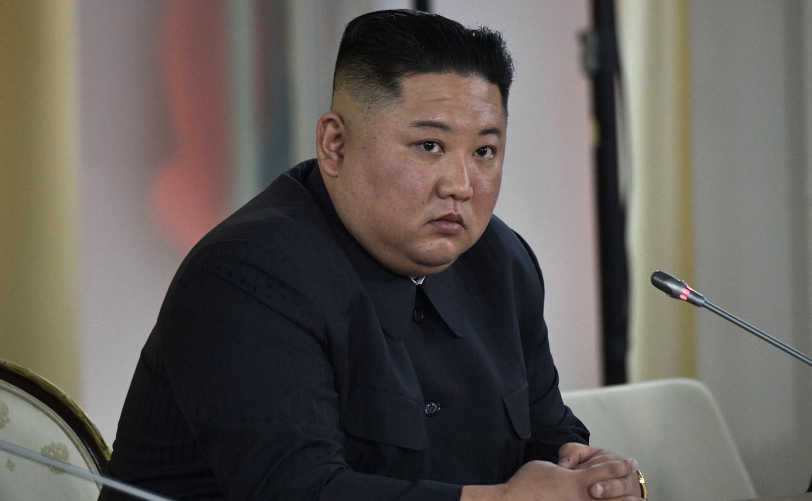 Kim Jong-un em frente a um microfone 