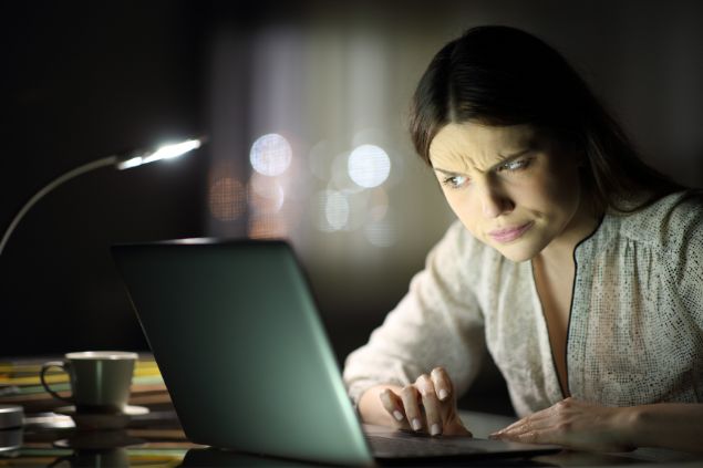 Mulher desconfiada olhando para o computador