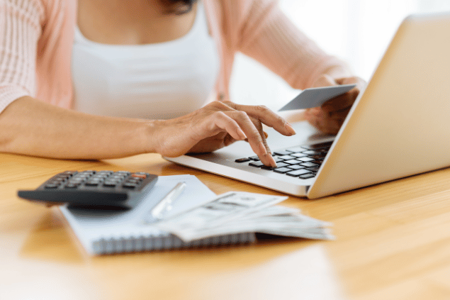 DragonImages / Canva Pro Mulher administrando finanças pessoais.