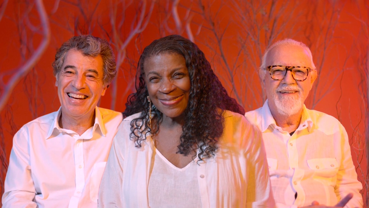 Imagem representando os artistas Paulo Betti, Zezé Motta e Ney Latorraca. Eles estão um ao lado do outro sorrindo.