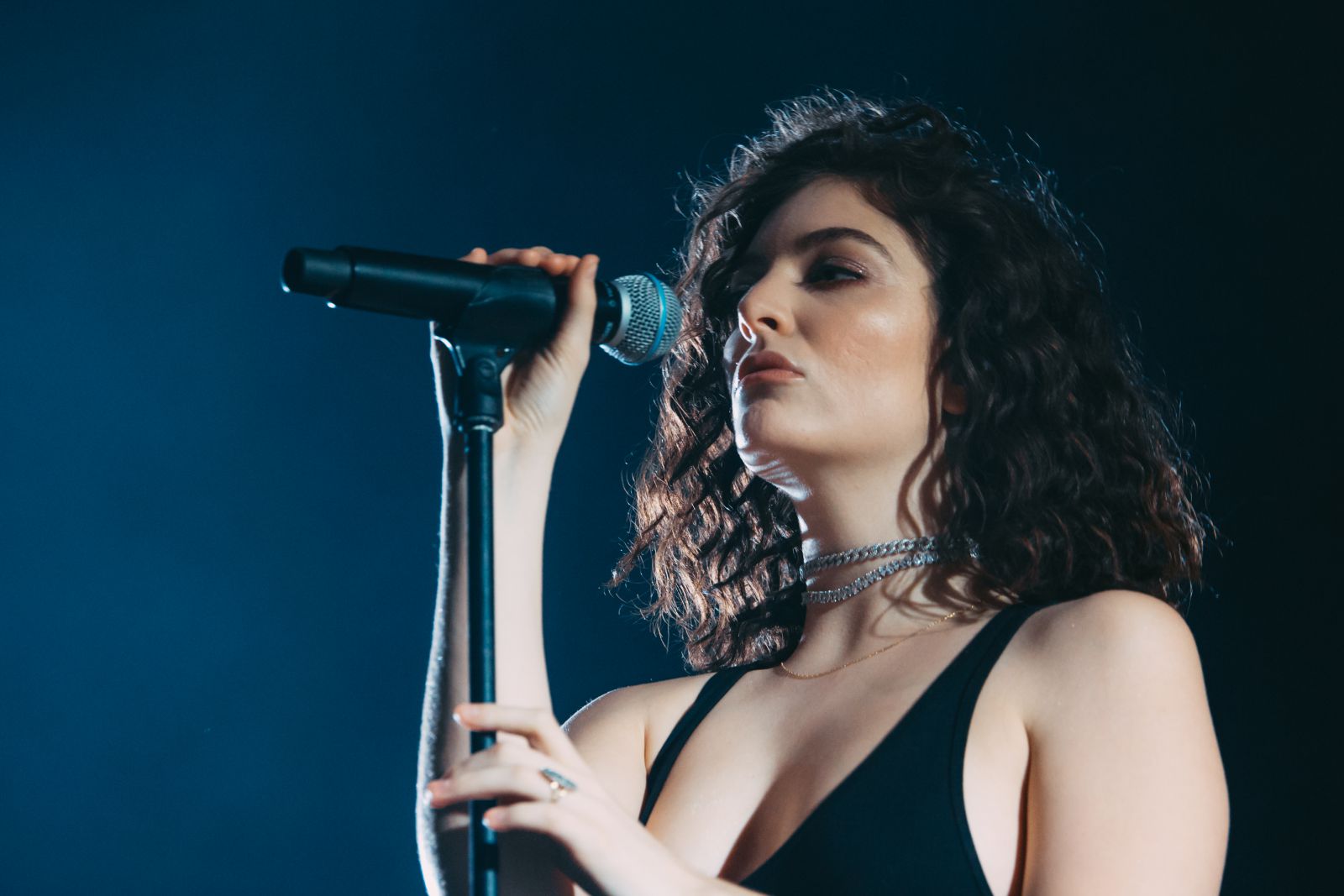 Lorde cantando no palco segurando microfone