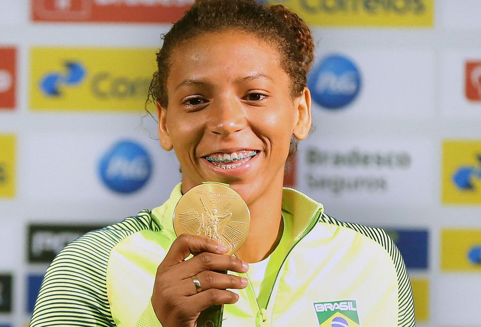 Rafaela Silva com medalha de ouro na mão direita nas Olimpíadas do Rio 2016