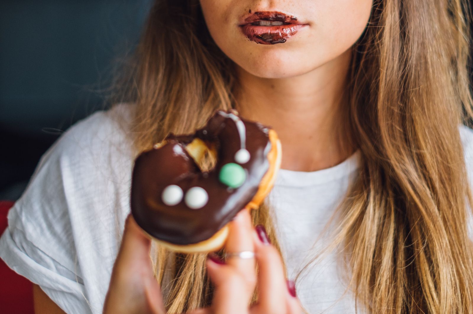 Mulher comendo donut de chocolate