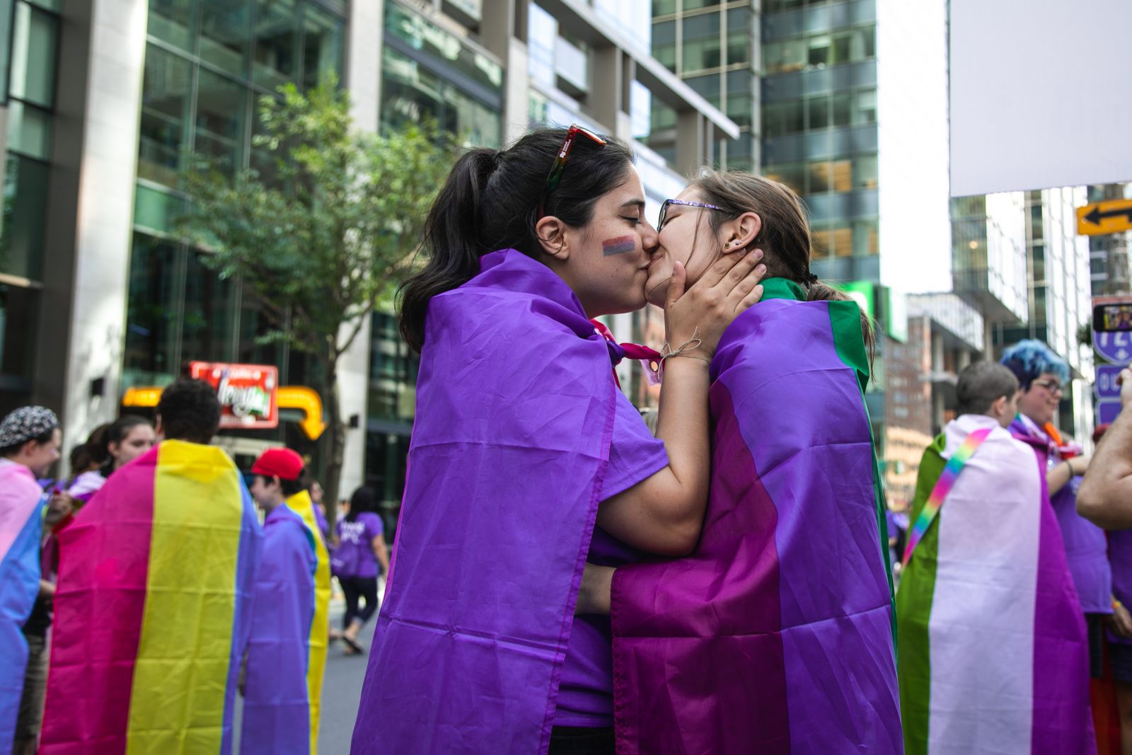 Duas mulheres se beijando em parada de rua.