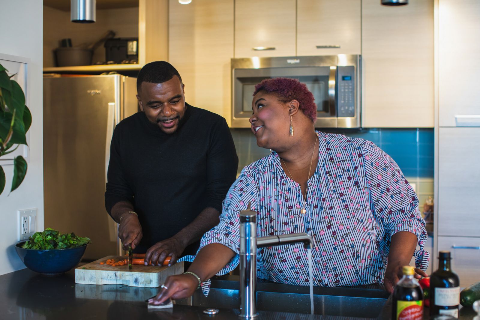 Homem e mulher juntos na cozinha preparando uma refeição