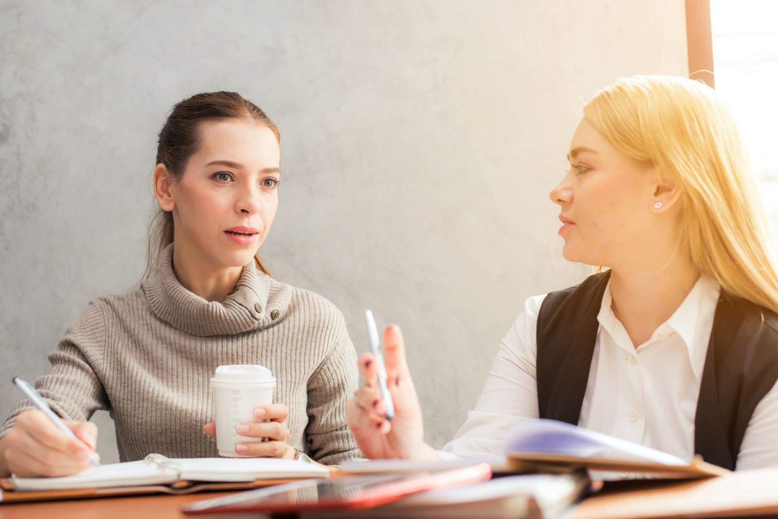 Duas mulheres conversando em ambiente de trabalho