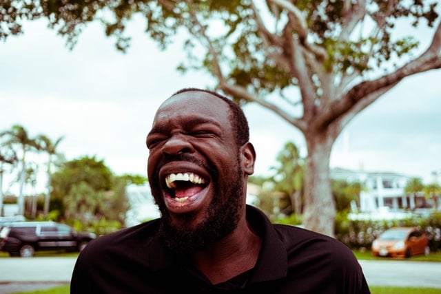 Homem negro rindo.