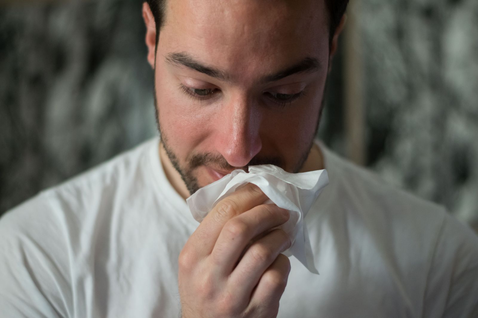 Homem limpando nariz com lenço
