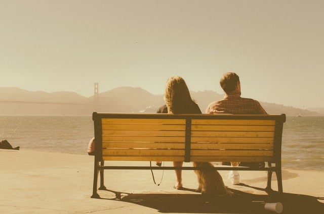 Homem e mulher sentados num banco.