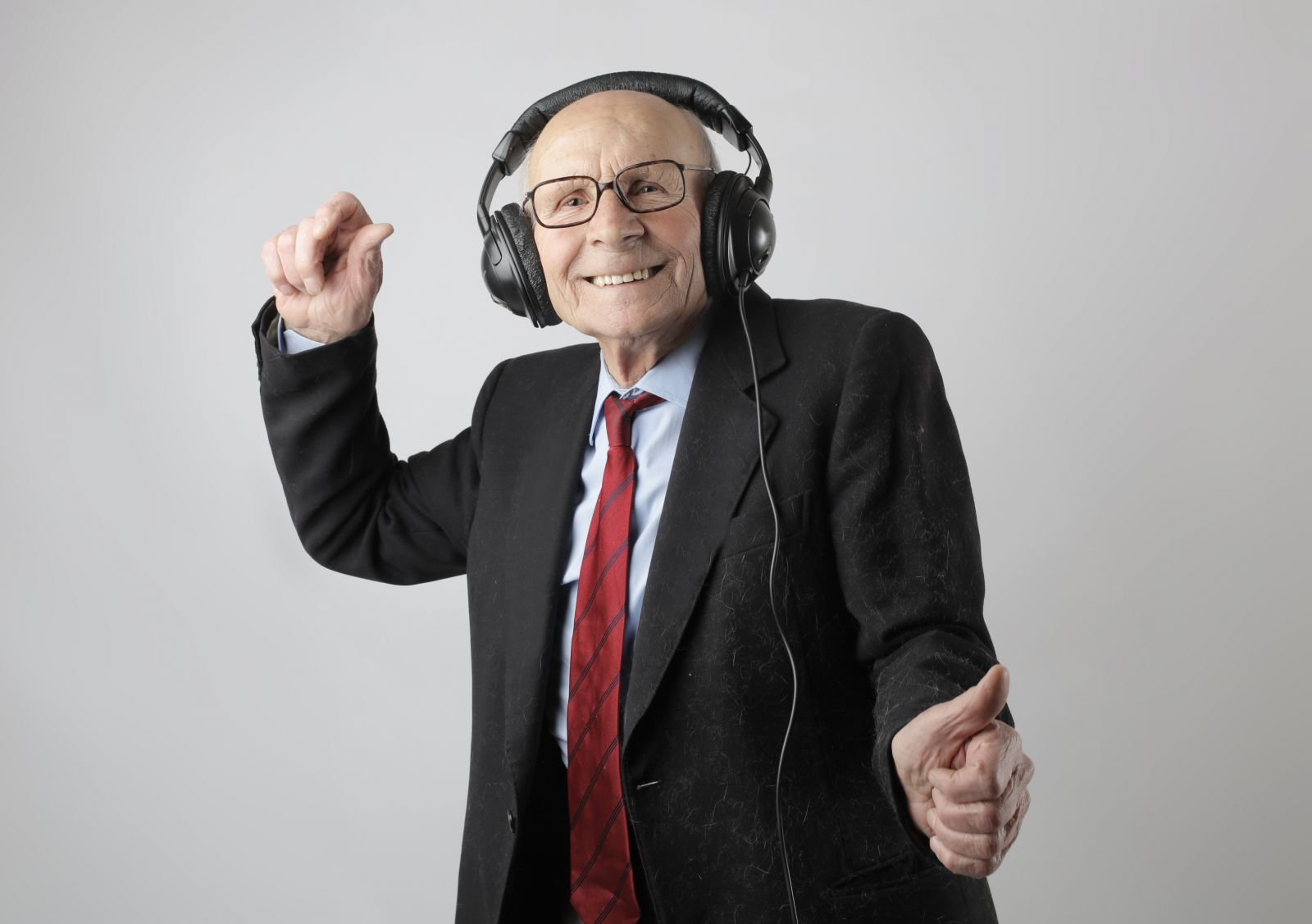 Homem idoso dançando e ouvindo música em seus fones de ouvido.