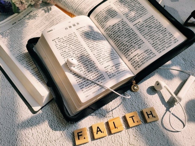 Bíblia aberta com fones em cima e palavra 