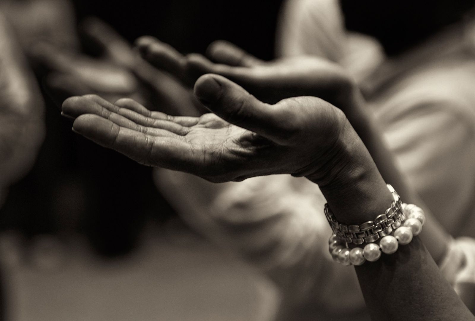Mãos de uma mulher com as palmas para cima, em sinal de oração.