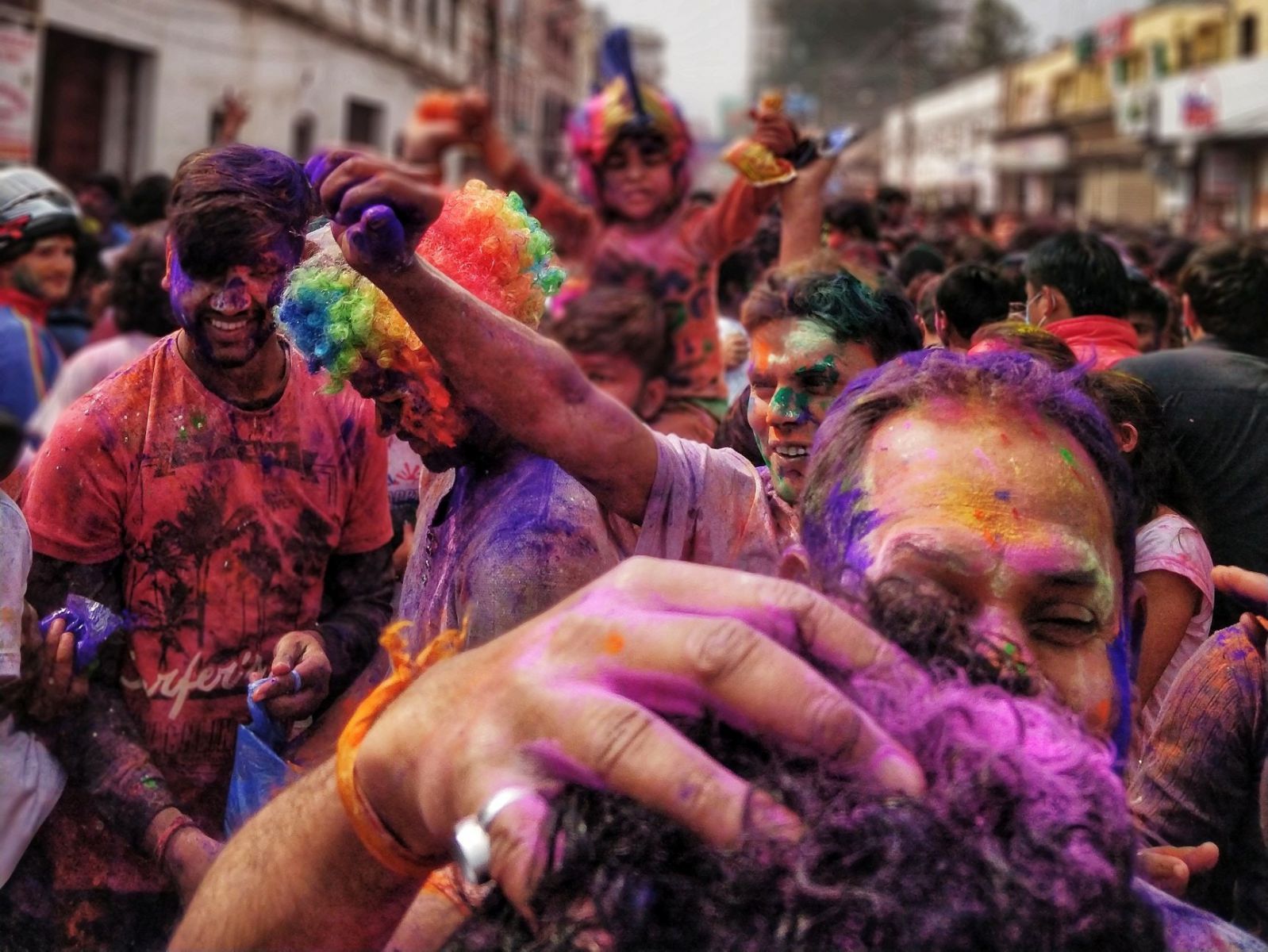 Pessoas sujas de tinta em pó durante festa de rua.