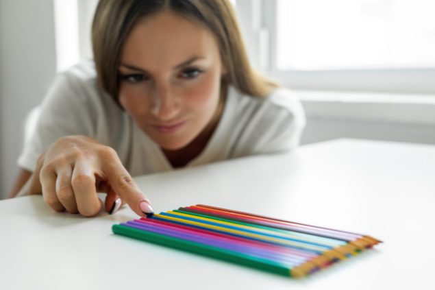 Mulher arrumando os lápis de forma perfeita