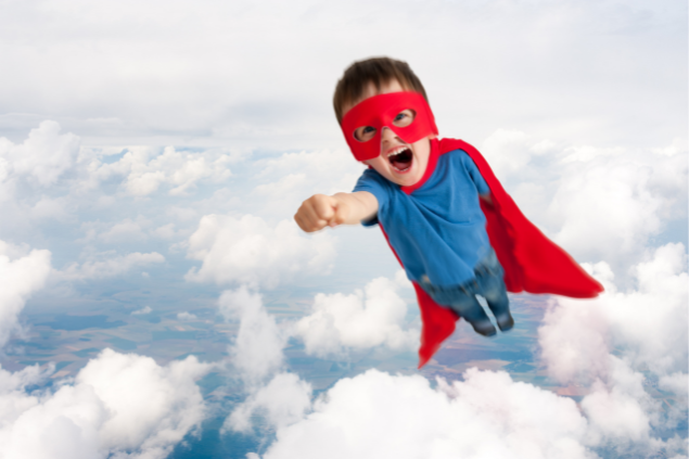 Menino vestido de super-herói voando 