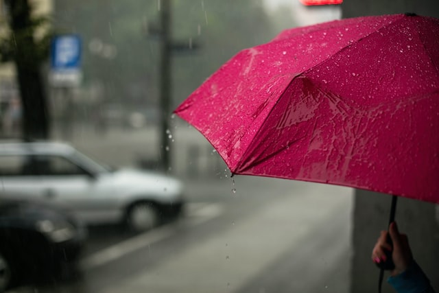 Guarda-chuva rosa na chuva.