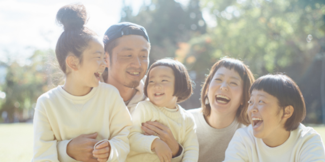 Família asiática sorridente em parque. 