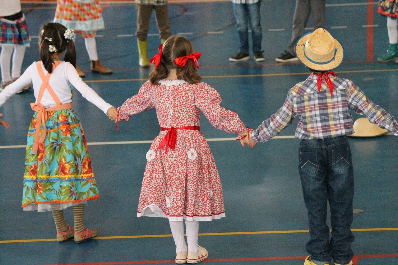 Crianças dançando quadrilha em quadra de escola.