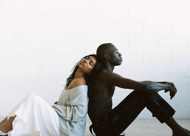 Gemma Chua-Tran / Unsplash Homem e mulher negros de costas um para o outro.