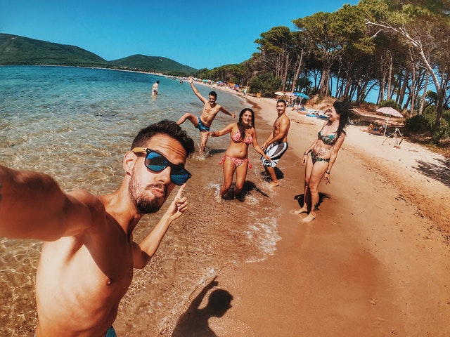 Amigos tirando uma selfie na praia.