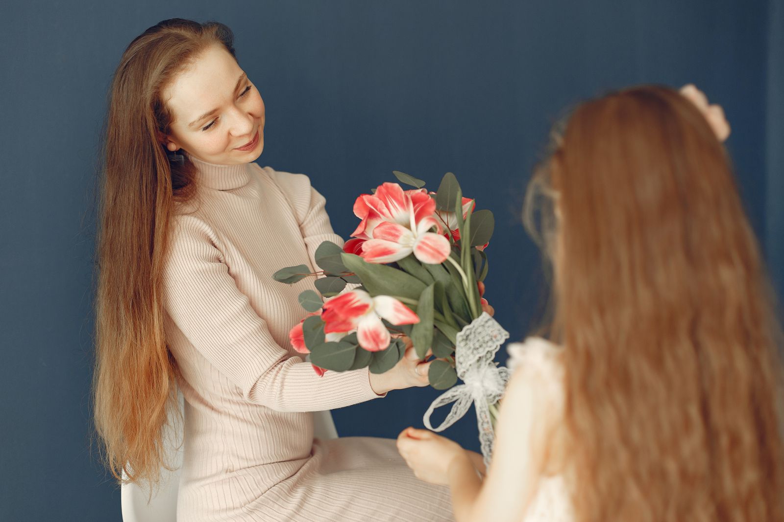 Mulher entregando um buquê de flores para sua gêmea.