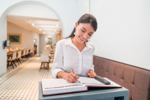 andresr / Getty Images Signature Anfitriã em um salão de festas