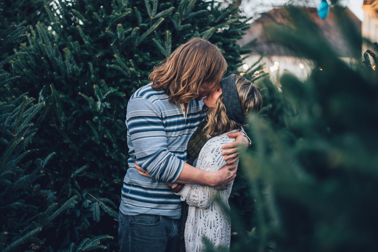 Homem abraçando e beijando uma mulher em um jardim