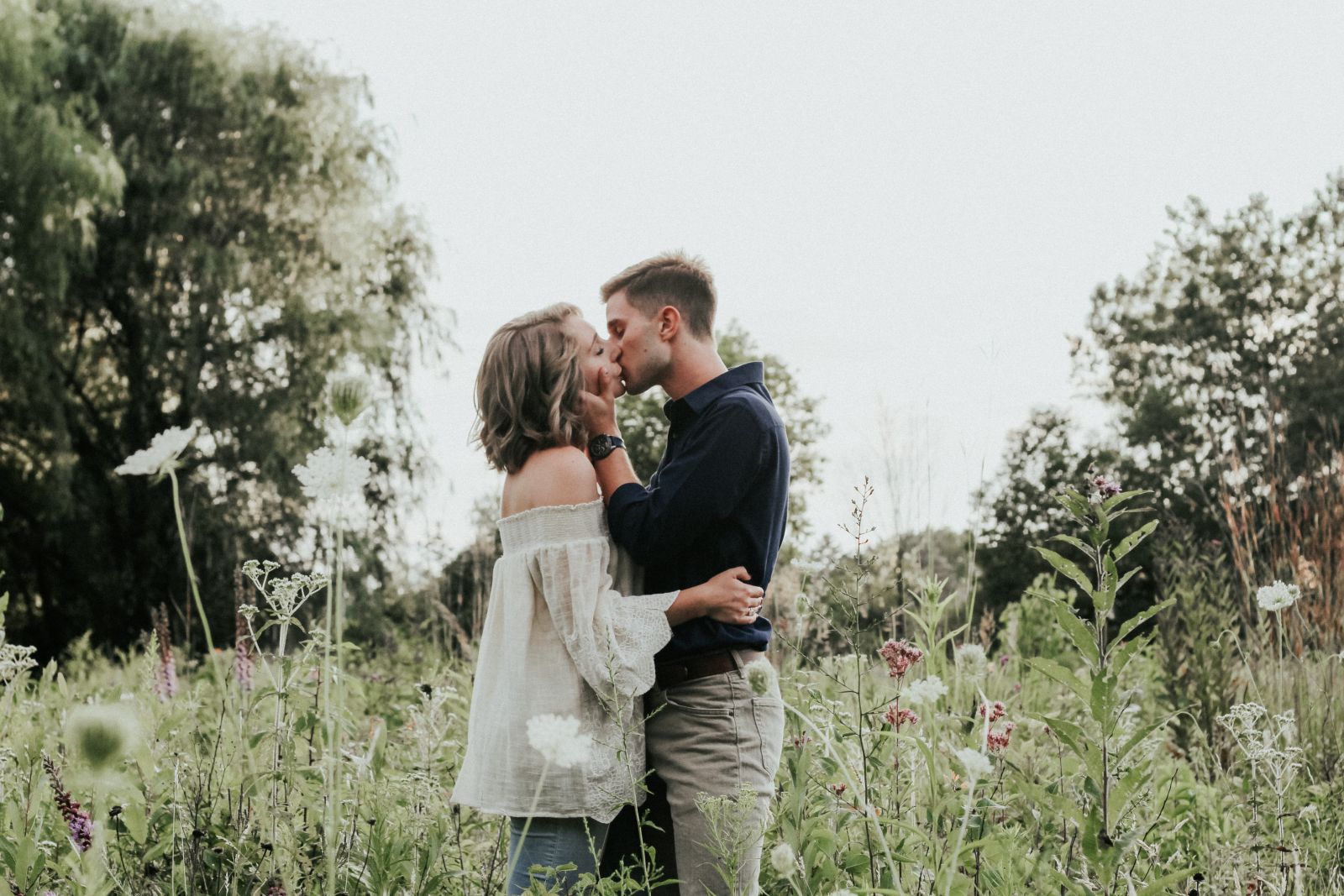 Casal se beijando em um campo gramado