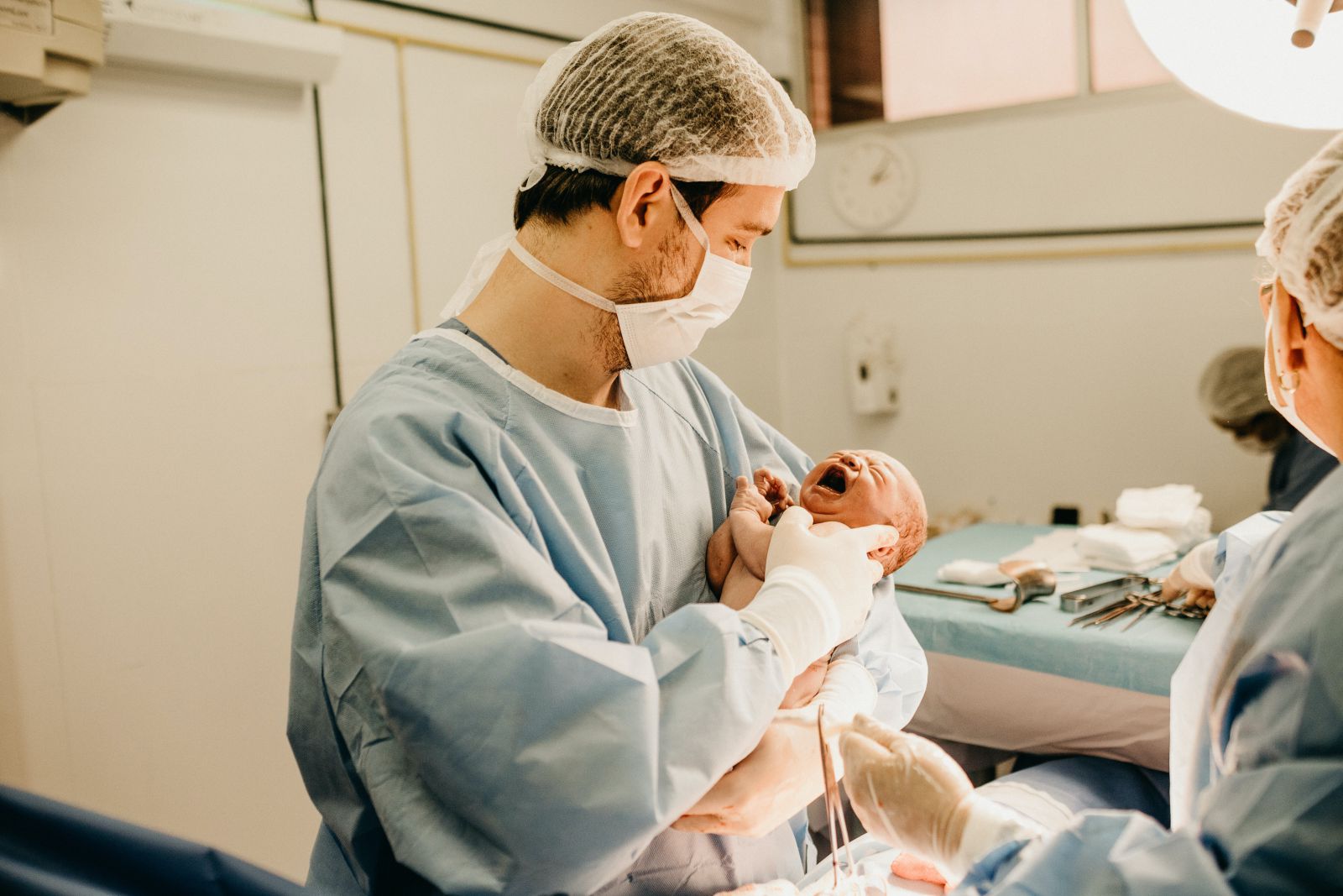 Médico segurando bebê que acabou de nascer