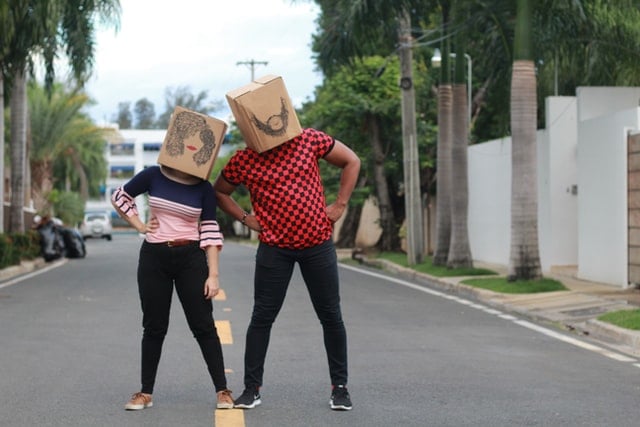 Homem e mulher com sacos de papel na cabeça.