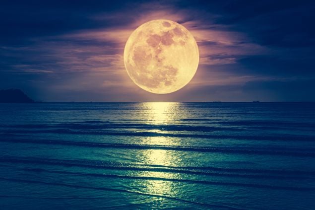Lua cheia sobre o mar calmo.