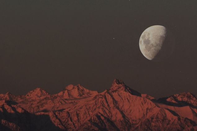 Lua minguante acima de uma superfície rochosa.