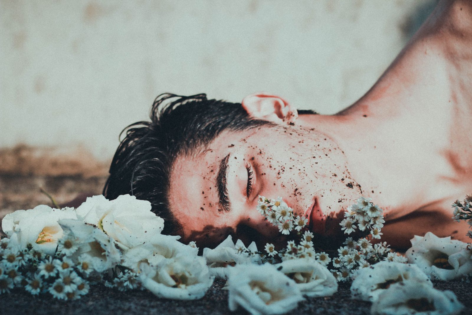 Homem deitado em meio a flores