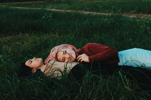 Casal de duas mulheres deitadas na grama
