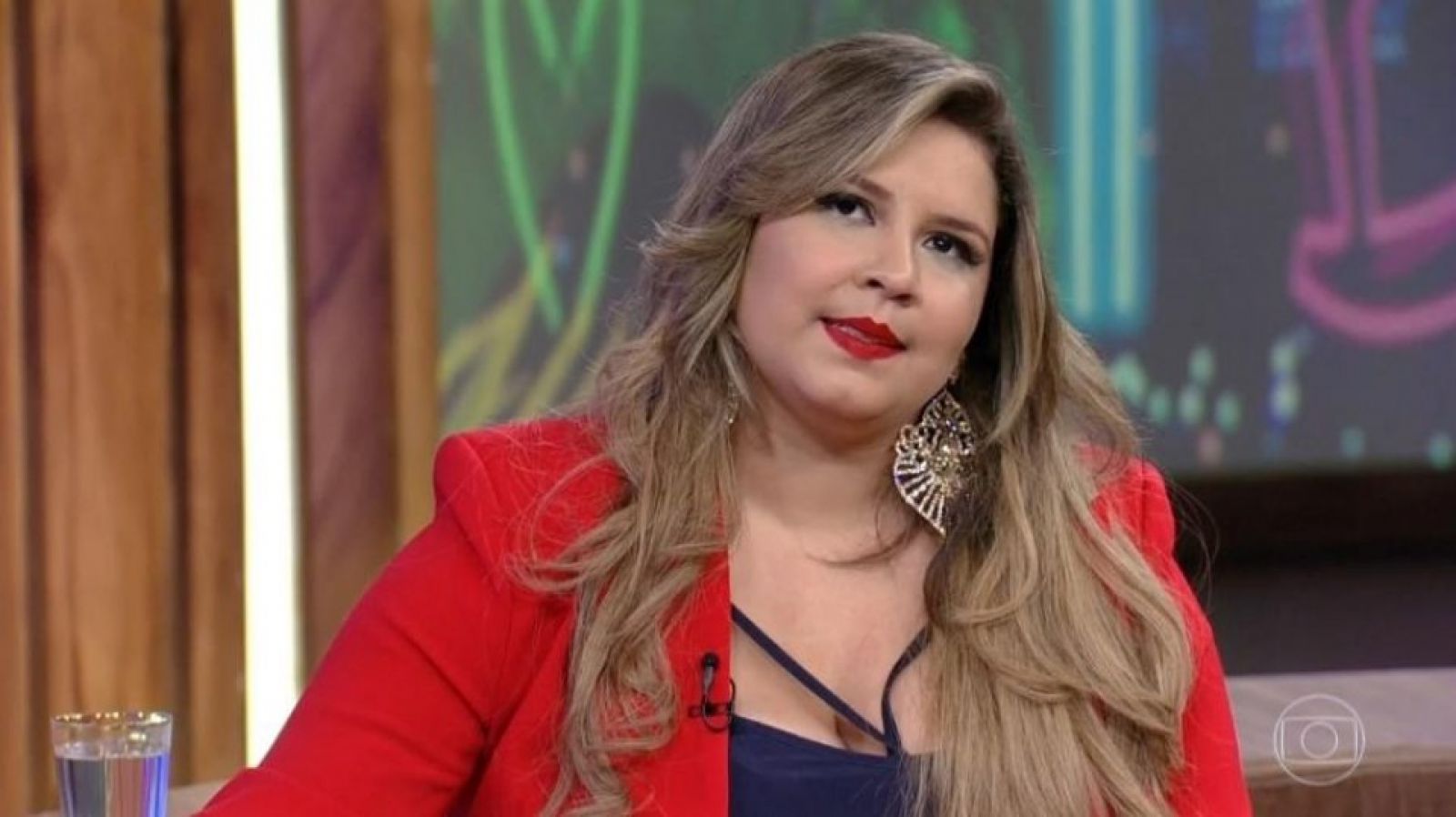 Cantora Marília Mendonça usando blazer vermelho.