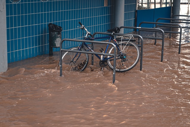 Bicicletas em enchente de água marrom.