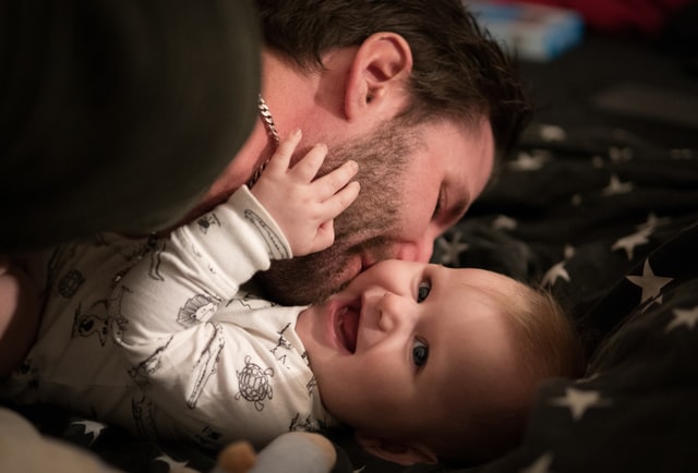 Pai beijando a bochecha de seu filho bebê