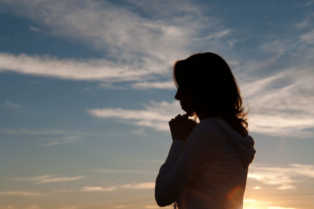 Silhuete de uma mulher orando