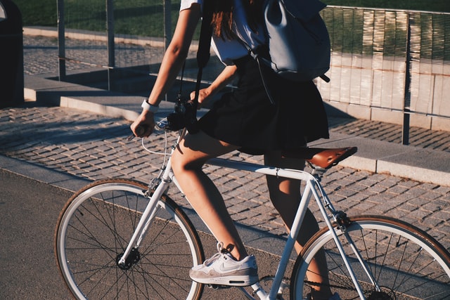 Mulher branca andando de bicicleta.