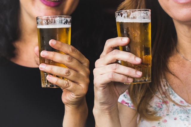 Mulheres segurando copos de cerveja.