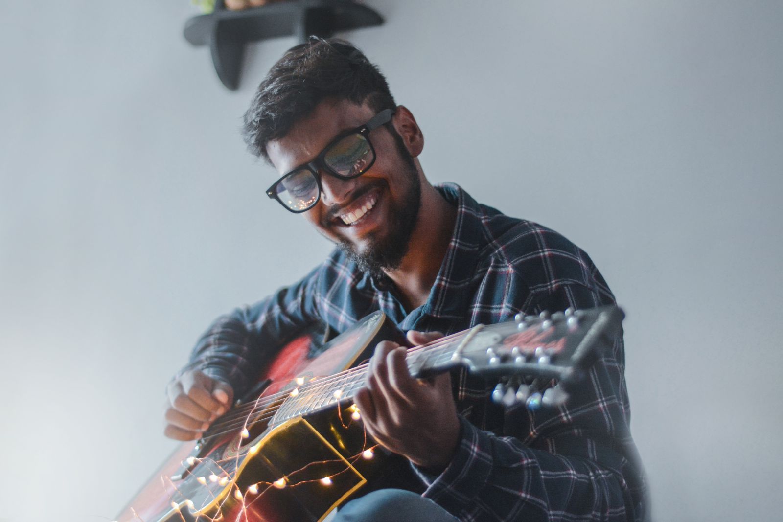 Homem tocando violão e sorrindo