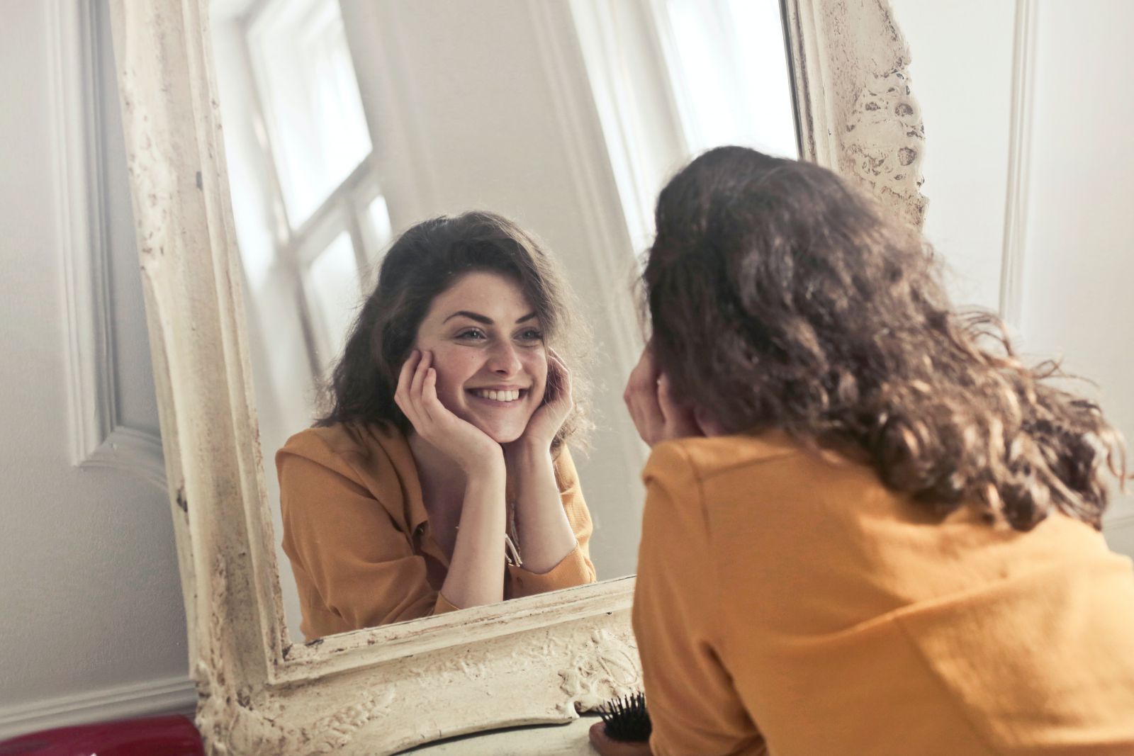 Mulher sorrindo olhando para o espelho