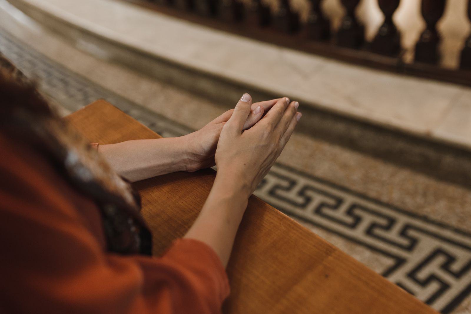 Mulher orando com as mãos unidas