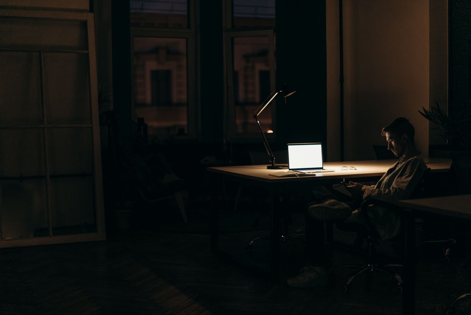 Homem sozinho em um escritório escuro