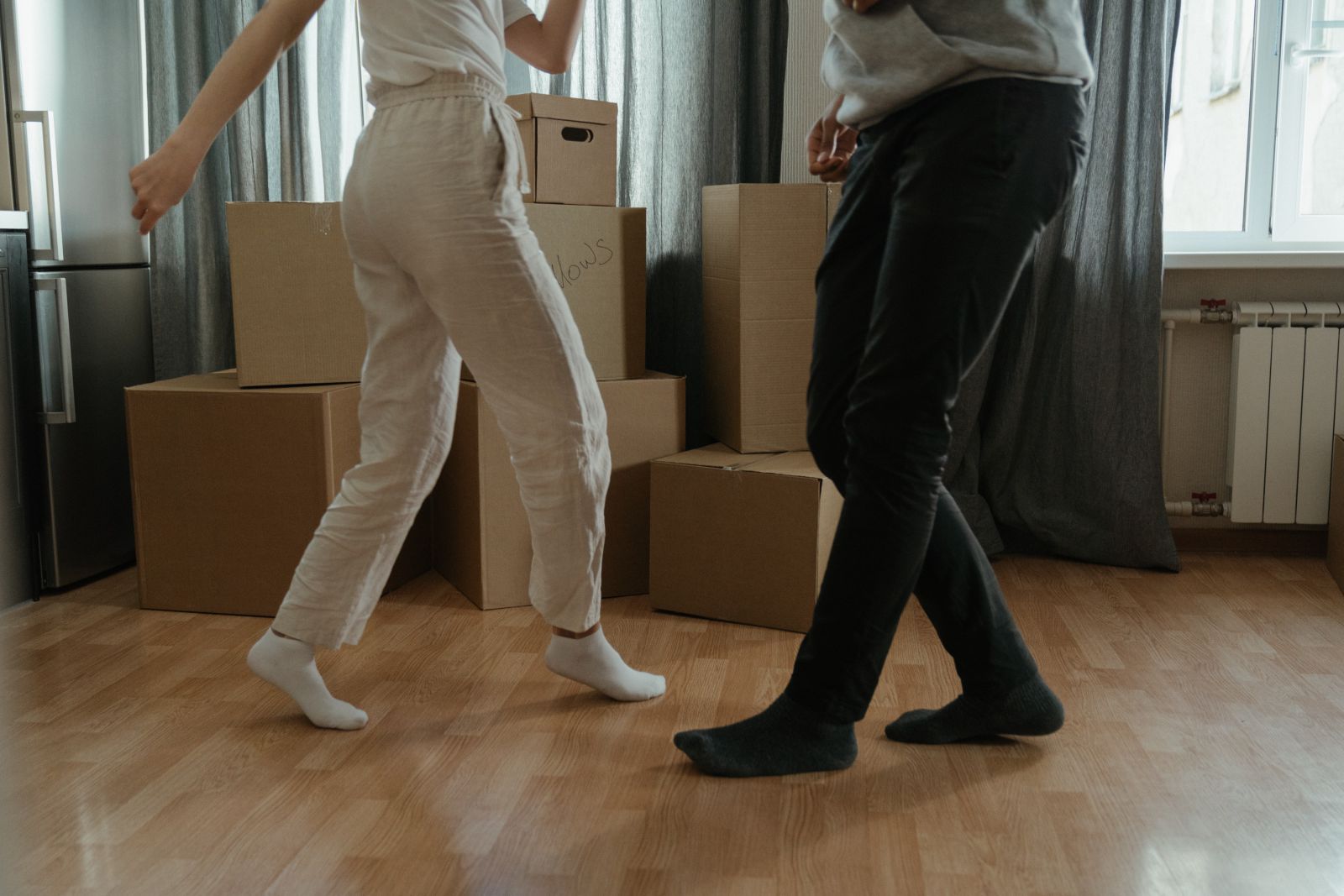 Duas pessoas dançando em casa ao lado de caixas