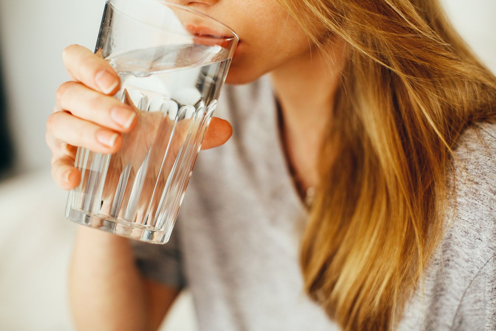 Mulher bebendo água em um copo
