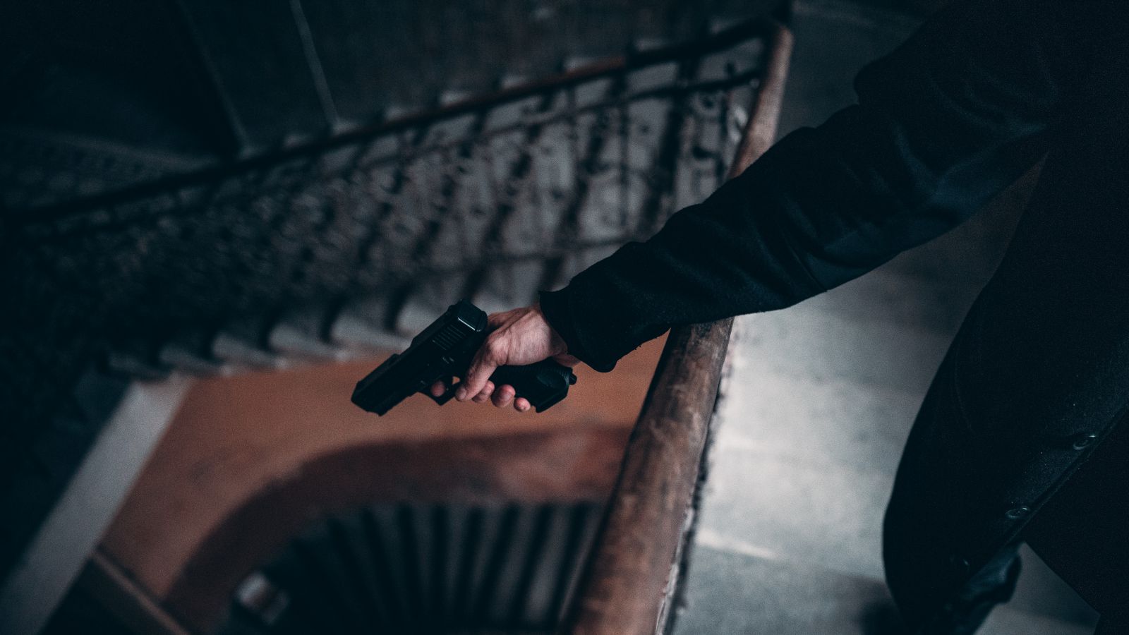 Homem em uma escadaria segurando arma 