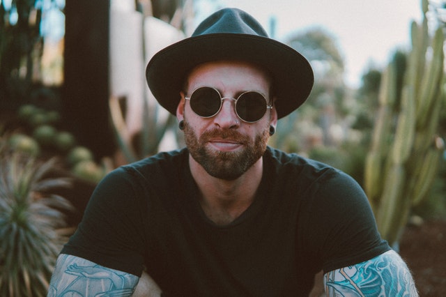 Homem de chapéu e óculos de sol sorrindo
