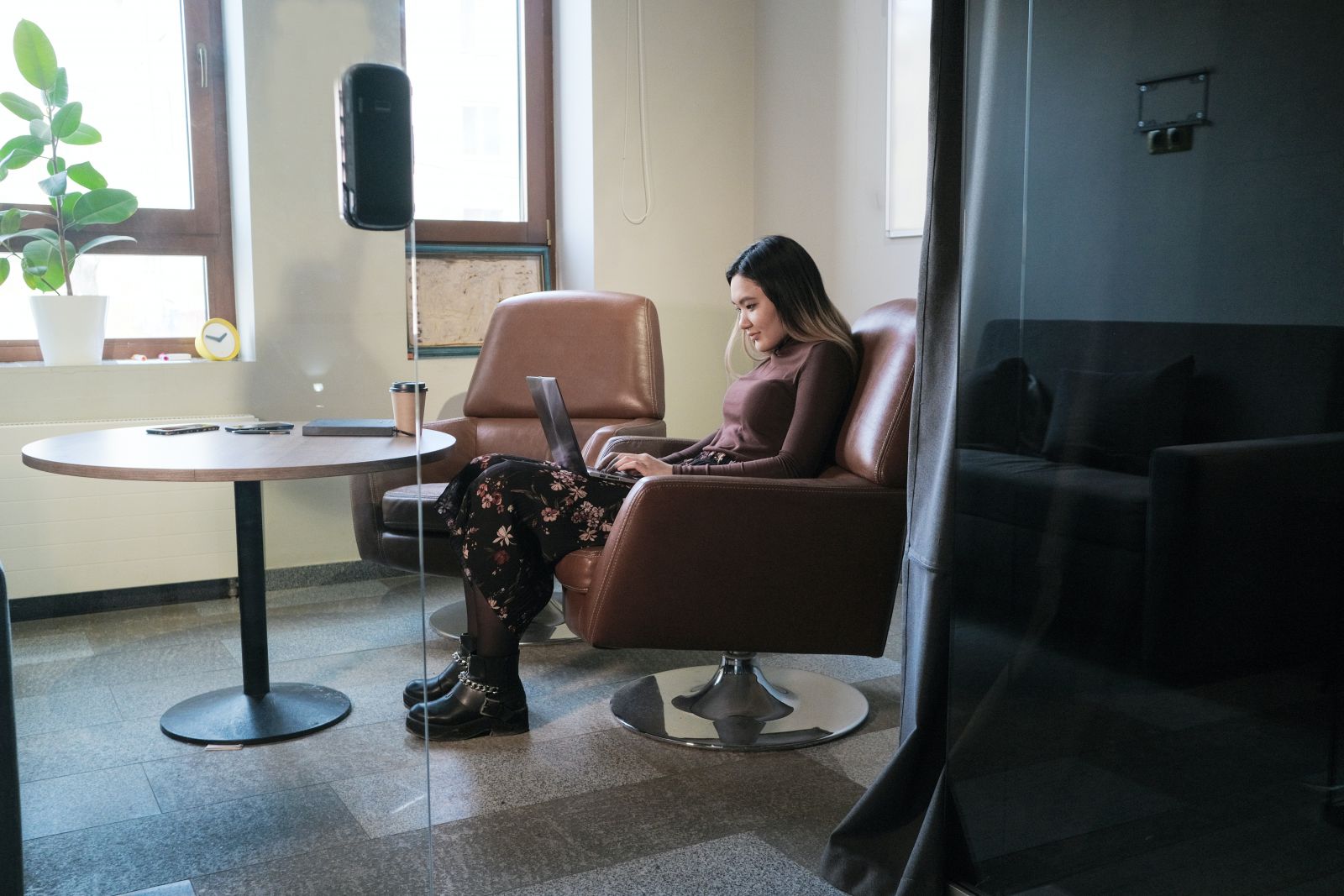 Mulher sentada em uma cadeira em um escritório usando notebook